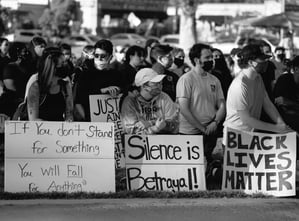 BLM protestors kneeling with signs